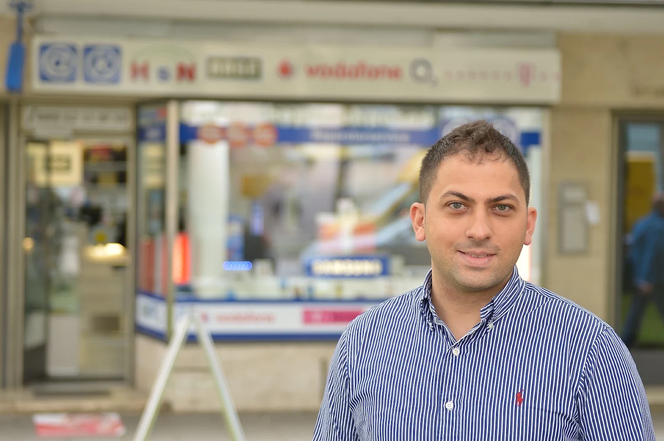 Inhaber des Handy Shop Neuhausen vor dem Laden